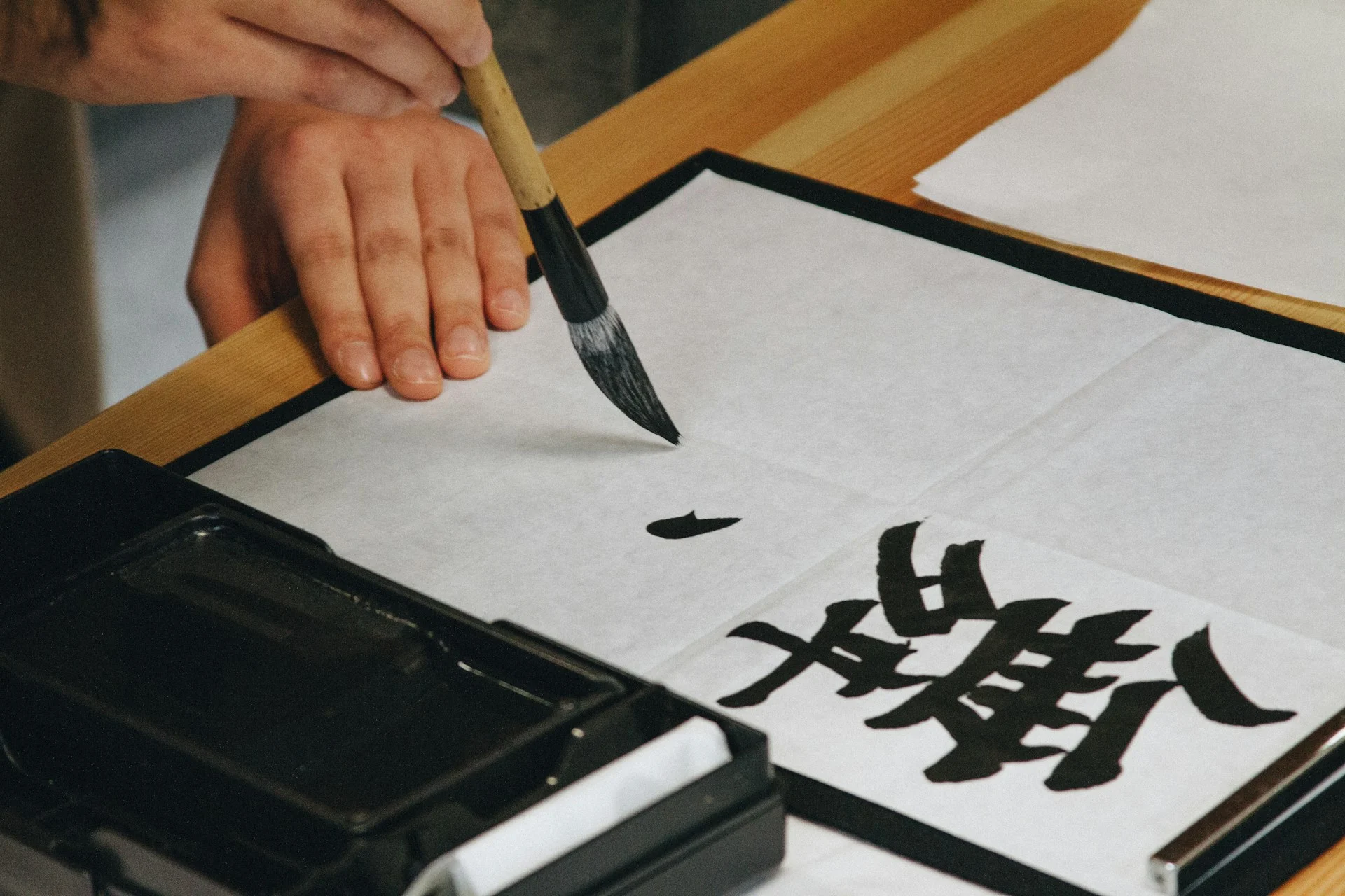 Calligraphy brush dipped in black ink, the core of an AI calligraphy generator's target style
