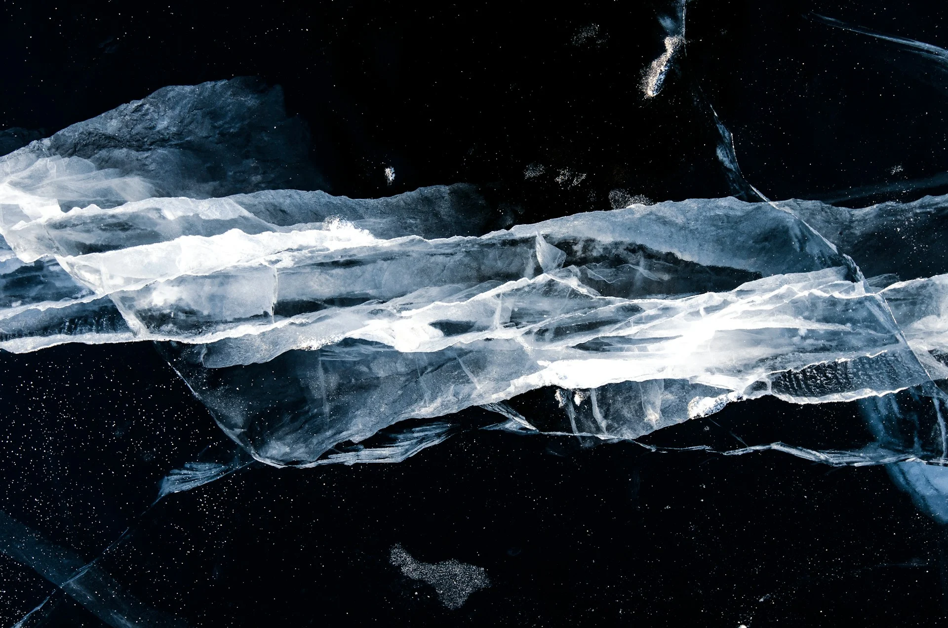 Towering ice shelf cliff above dark ocean water, like the ancient Baffin Bay ice shelf