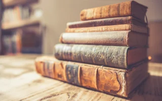 Stack of old books in dramatic light, representing the Cyberselfish reissue