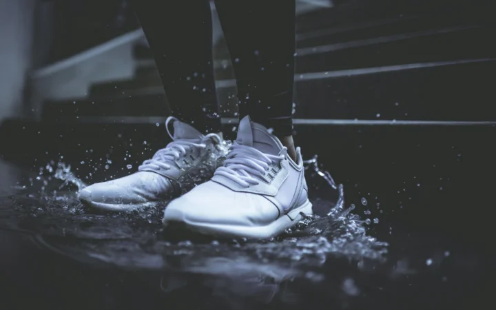 Running shoe lit against a dark background, illustrating Deckers earnings and HOKA
