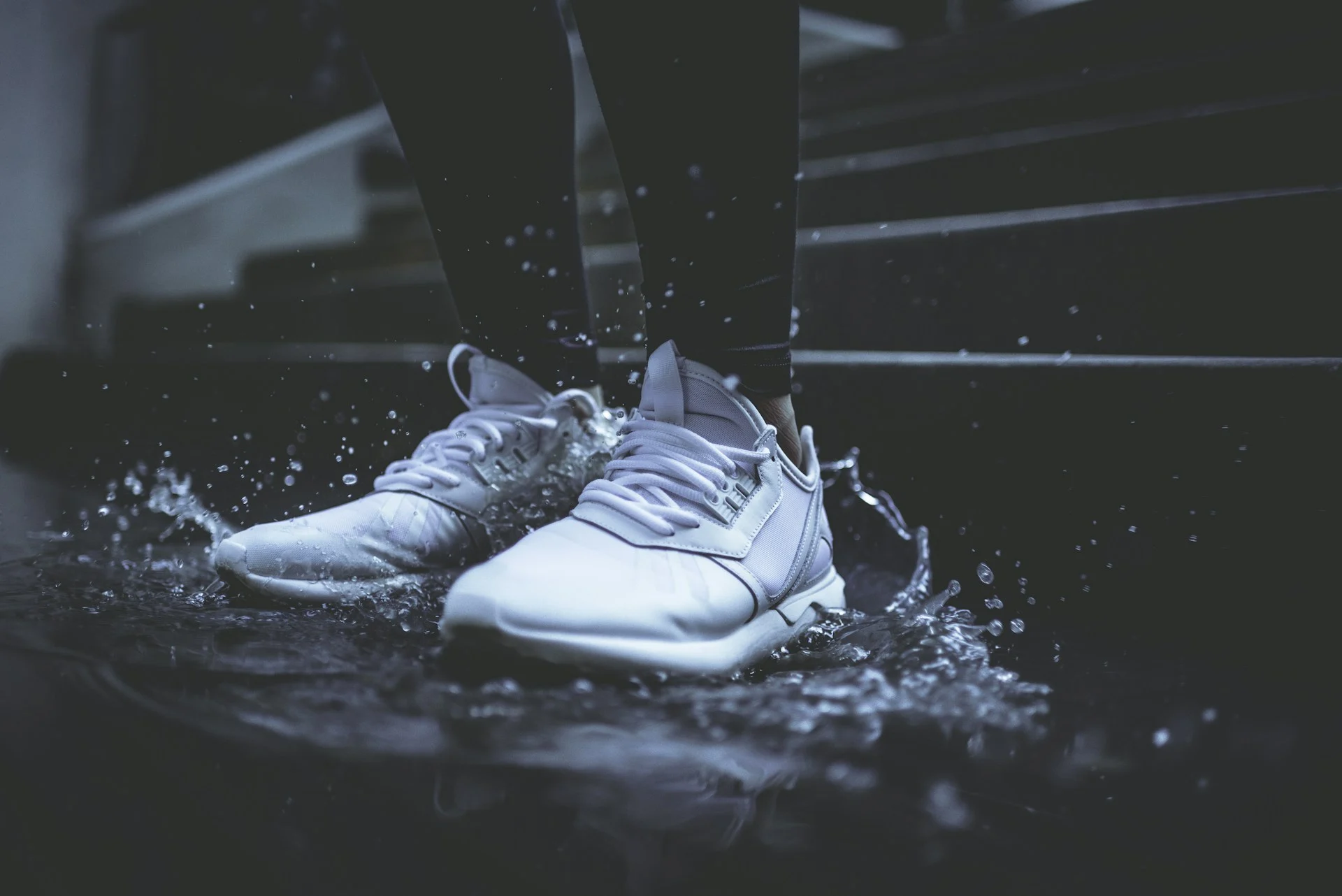 Running shoe lit against a dark background, illustrating Deckers earnings and HOKA