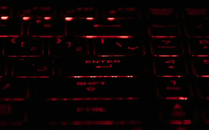 Hands on a keyboard in red light, illustrating the Docomo data leak