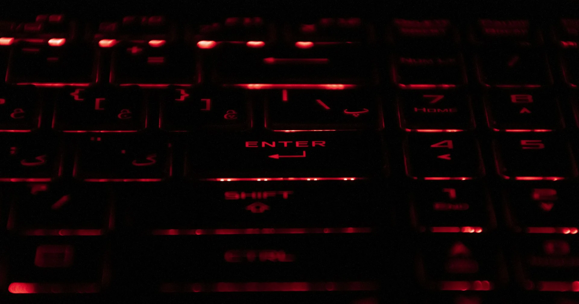 Hands on a keyboard in red light, illustrating the Docomo data leak