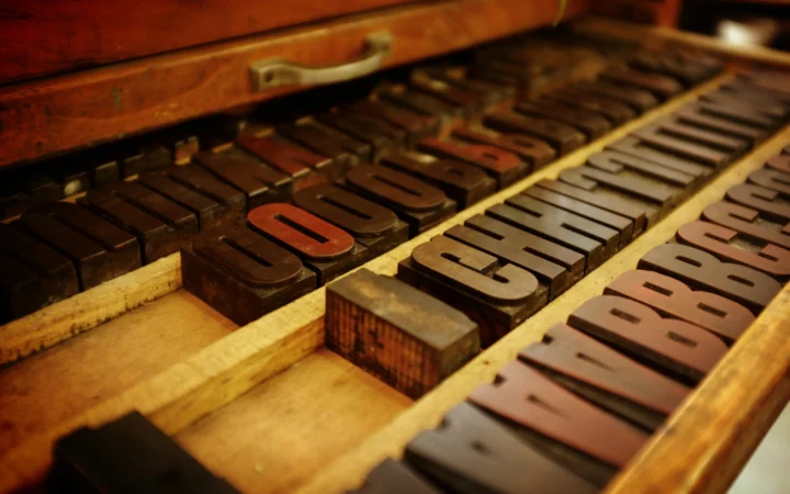 Metal letterpress type blocks in dramatic light, representing free fonts for Mac