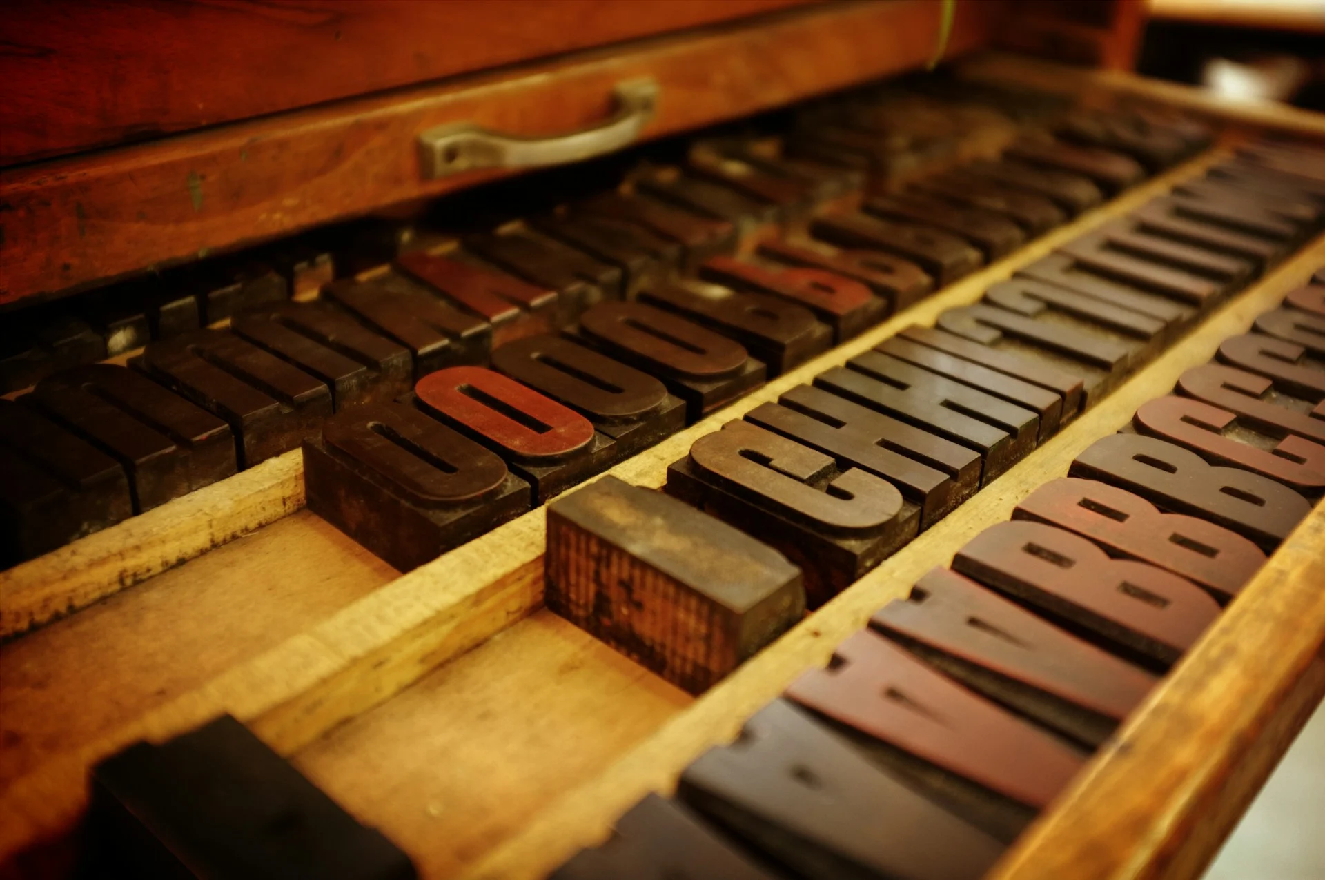 Metal letterpress type blocks in dramatic light, representing free fonts for Mac