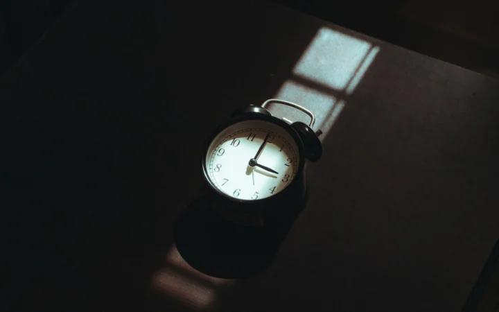 Glowing bedside alarm clock in a dark bedroom, illustrating the Hatch Sleep Clock review