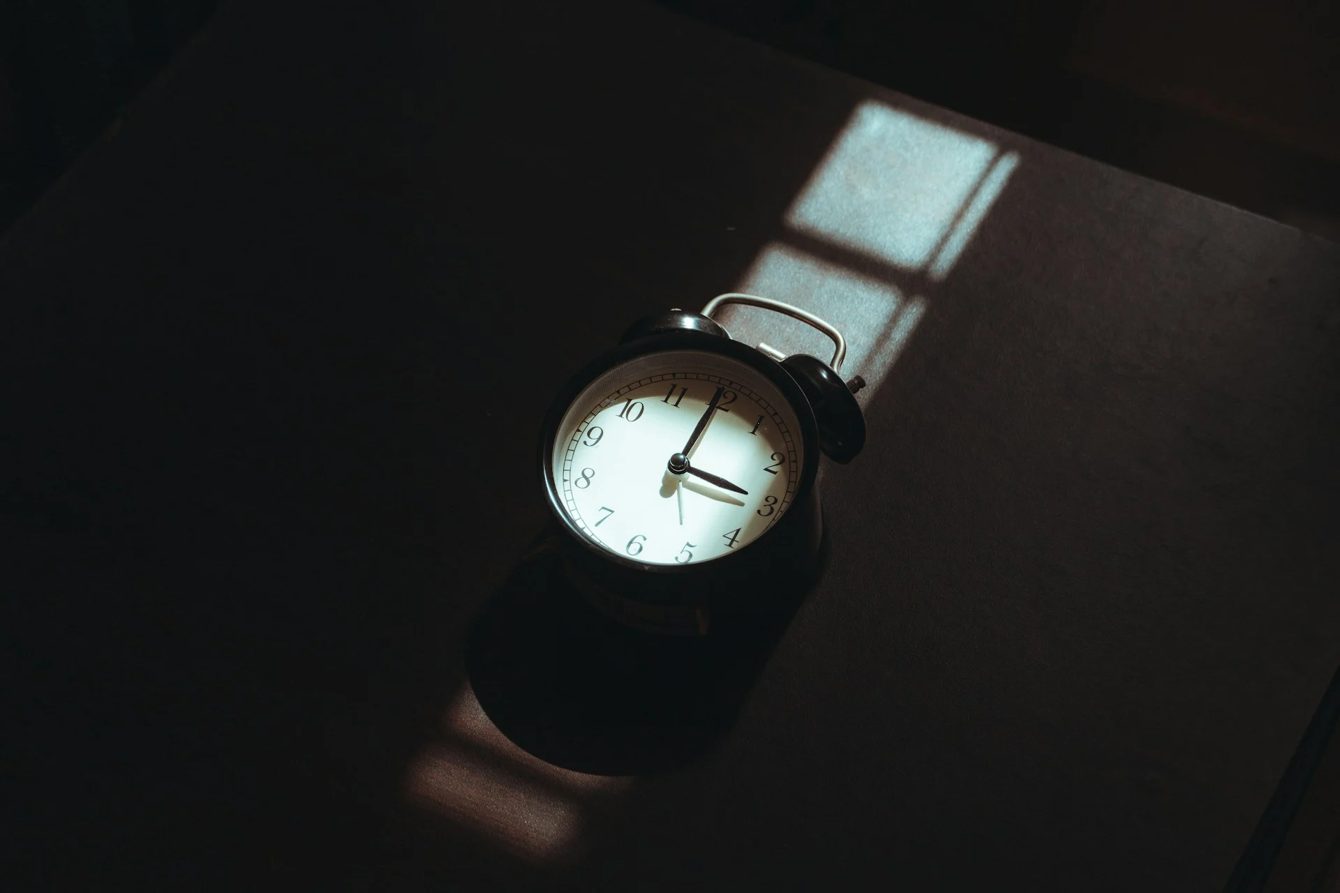 Glowing bedside alarm clock in a dark bedroom, illustrating the Hatch Sleep Clock review