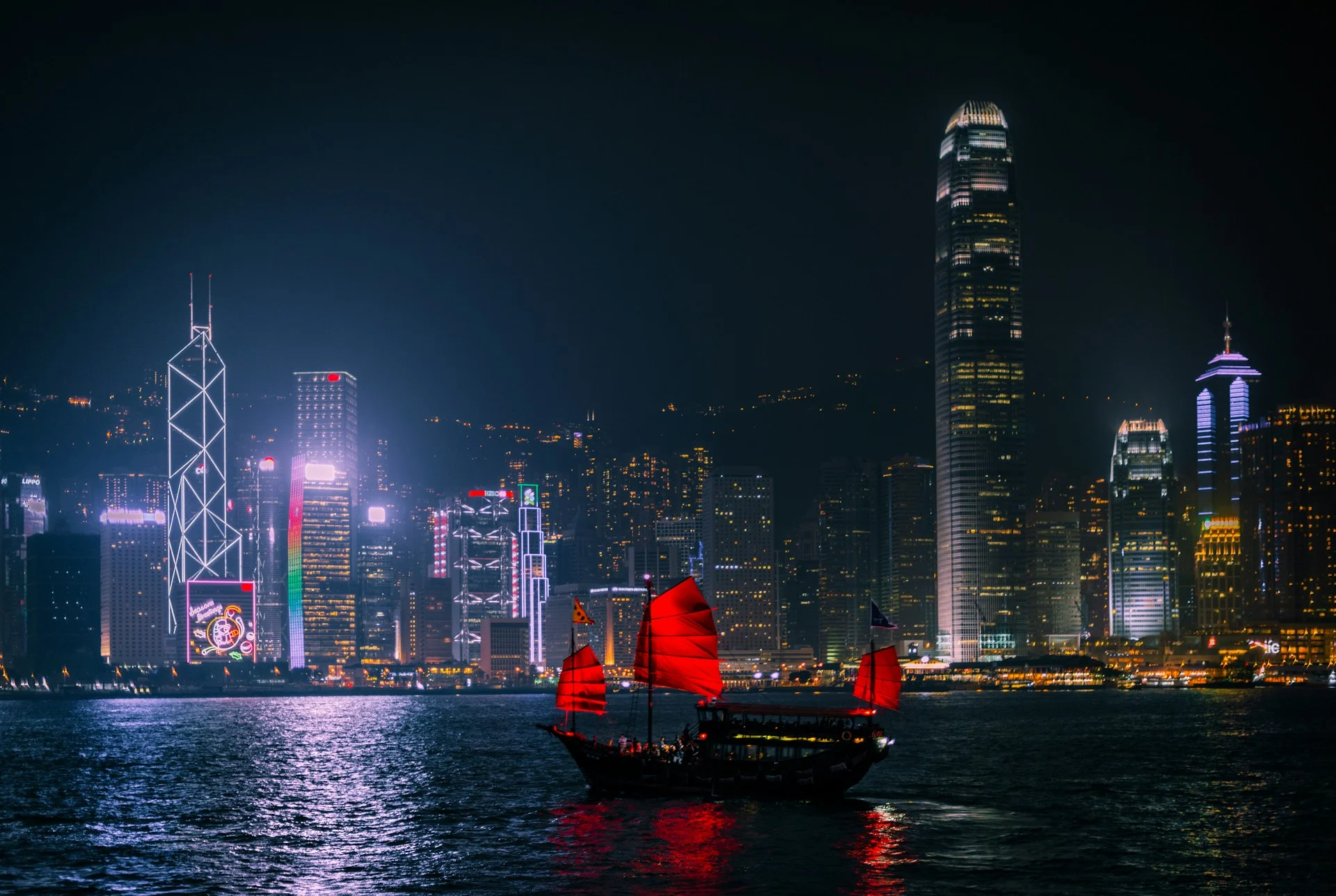 Hong Kong skyline lit up at night across Victoria Harbour, the Hong Kong vs Singapore wealth race