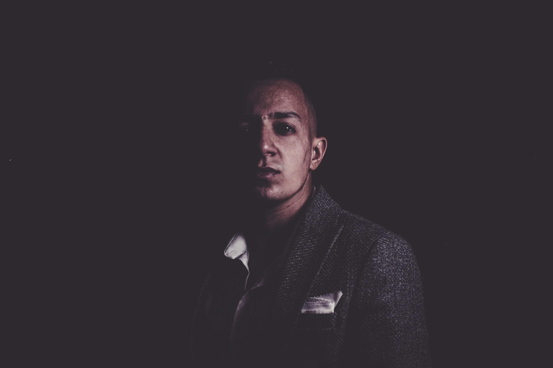 Man in a tuxedo in dramatic low light, evoking the Jack Lowden James Bond casting