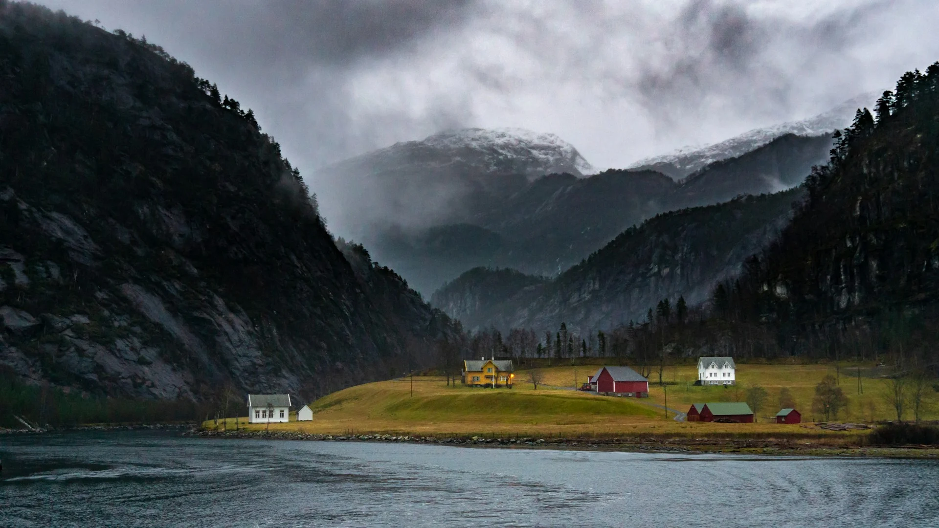 Salmon farming pens in an Icelandic-style fjord at dusk