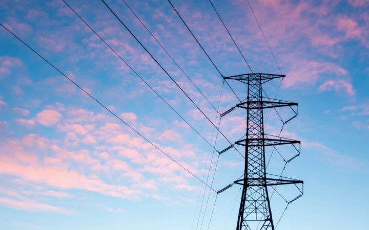High-voltage transmission towers carrying power lines at dusk