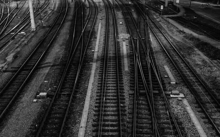 Railway tracks splitting at a switch at night, a metaphor for the Mouse-1 decision model choosing paths for AI agents