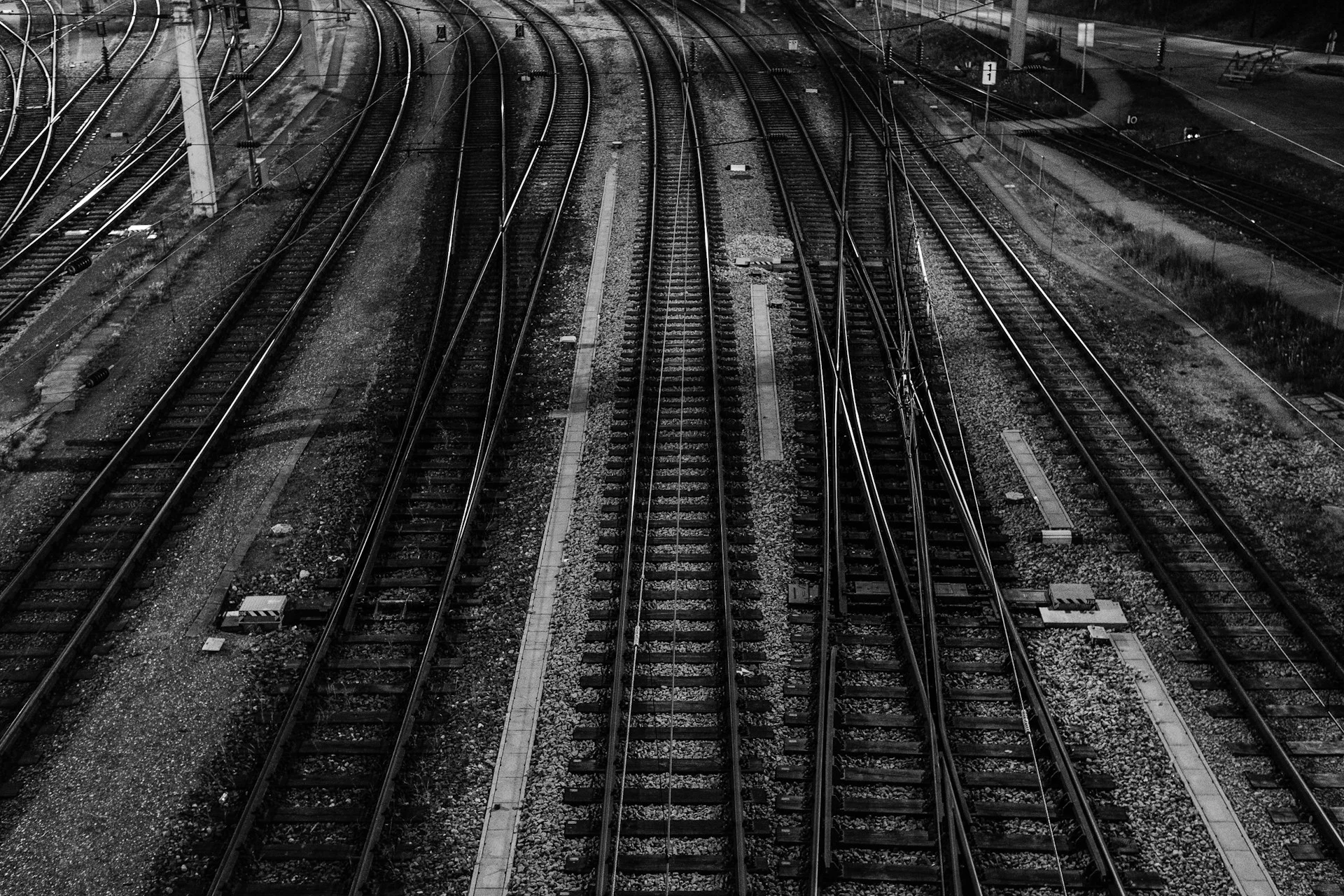 Railway tracks splitting at a switch at night, a metaphor for the Mouse-1 decision model choosing paths for AI agents