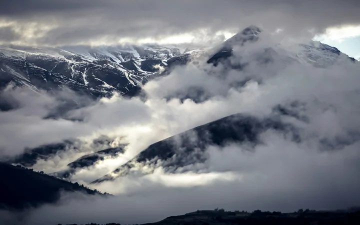 Dark storm clouds over New Zealand mountains, illustrating the NZ climate report on extreme weather