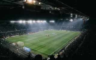 Football stadium floodlights lighting up the pitch at night, the setting for Olise's Ballon d'Or race