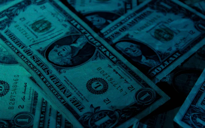 Stacks of dollar bills in dramatic light, representing the $30 billion OpenAI funding round
