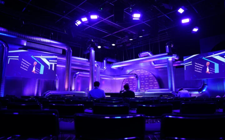 Empty conference stage under a spotlight, symbolising the Saudi FII postponed to 2027