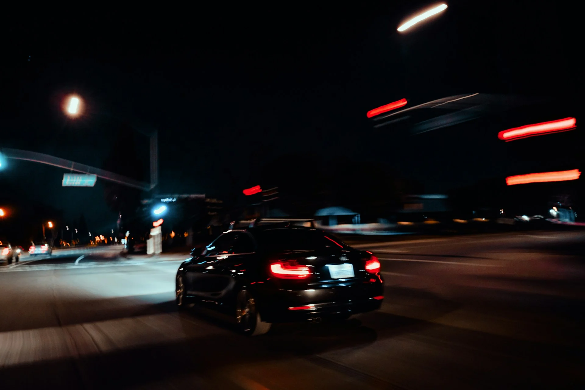 Electric car under dramatic red light, illustrating the fall in Tesla profit