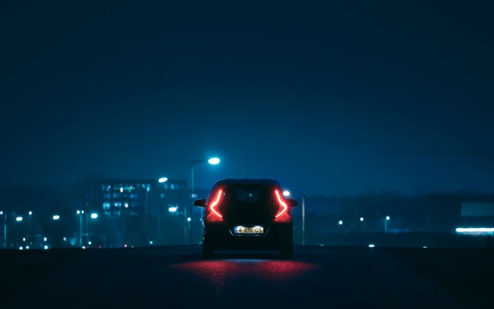 Self-driving car on a city street at night, symbolising Tesla's robotaxi bet