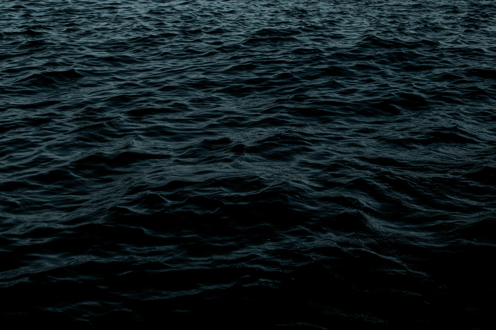 Submarine surfacing in a dark ocean, illustrating UK nuclear submarines at sea